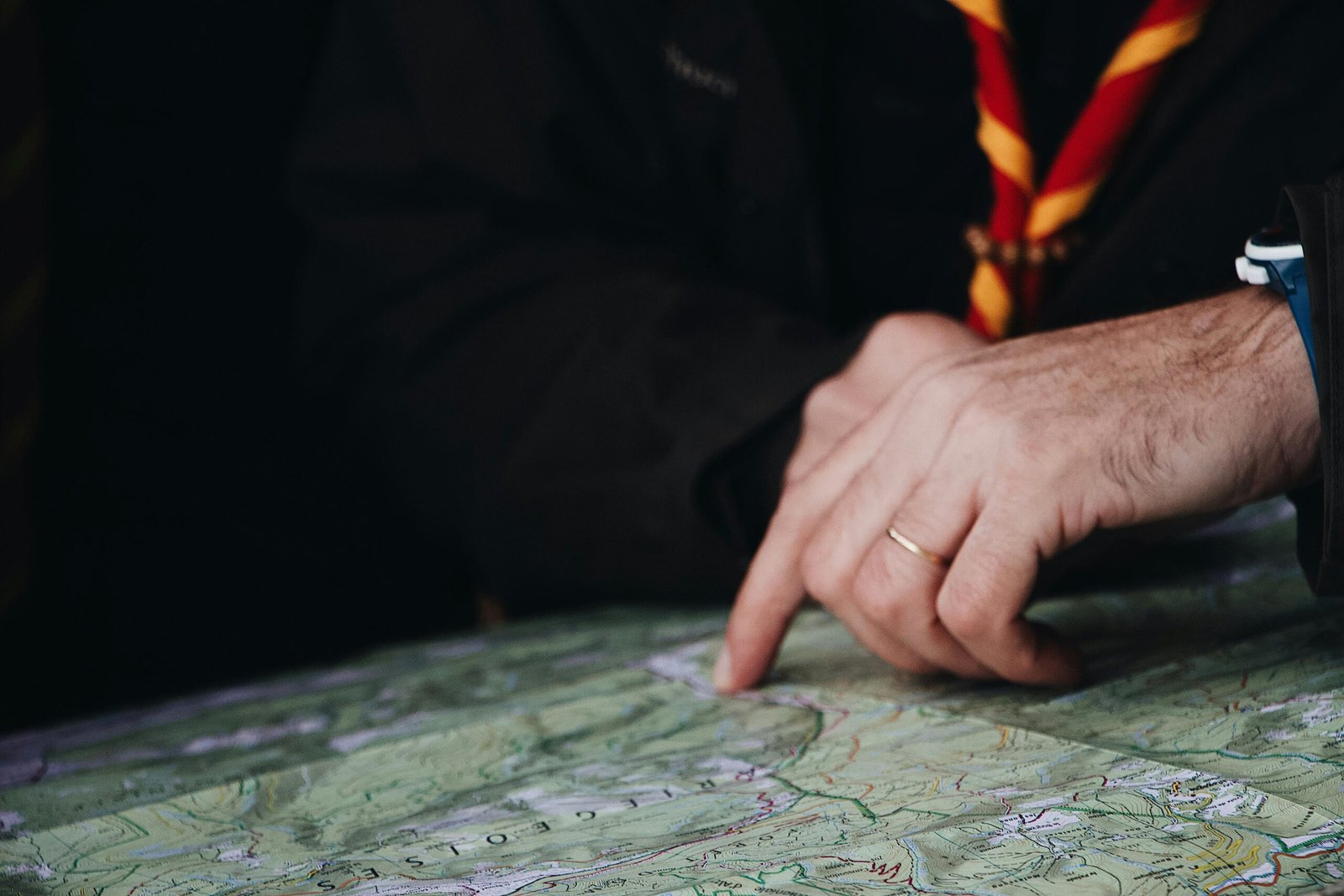 Close-up of a hand pointing to a map, suggesting a travel or navigation theme.